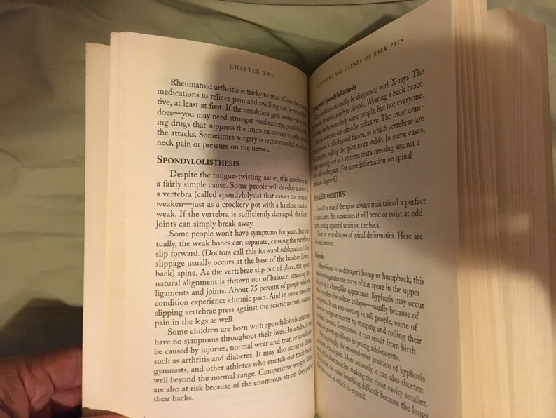 Puede incluir: Primer plano de una p&aacute;gina de libro con el t&iacute;tulo "Espondilolistesis" y una descripci&oacute;n de la condici&oacute;n. El texto trata sobre la causa, los s&iacute;ntomas y el tratamiento de esta condici&oacute;n, que afecta las v&eacute;rtebras de la columna vertebral.