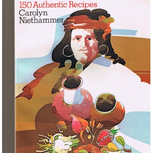 May include: A book cover with a colorful illustration of a Native American person holding a clay pot. The title of the book is "American Indian Food and Lore" and the subtitle is "150 Authentic Recipes". The author's name is Carolyn Niethammer.