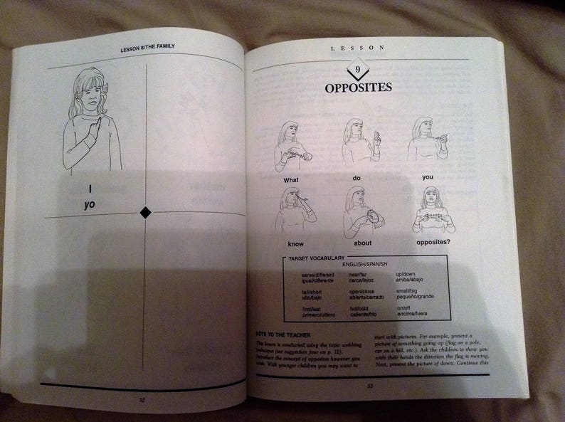 May include: A black and white illustrated book page with the title "Lesson 9: Opposites". The page features a series of illustrations of people signing words in American Sign Language. The words include "I", "What", "Do", "You", "Know", "About", and "Opposites?"