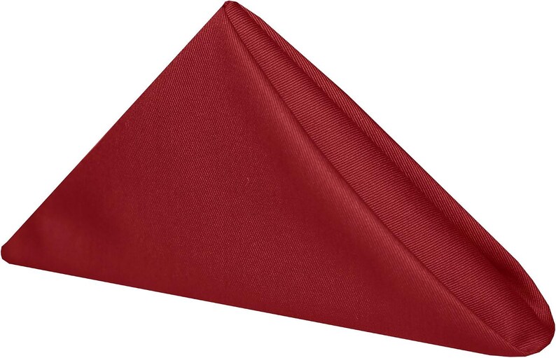 A folded red napkin. The napkin is a cotton napkin manufactured by Premier Table Linens.