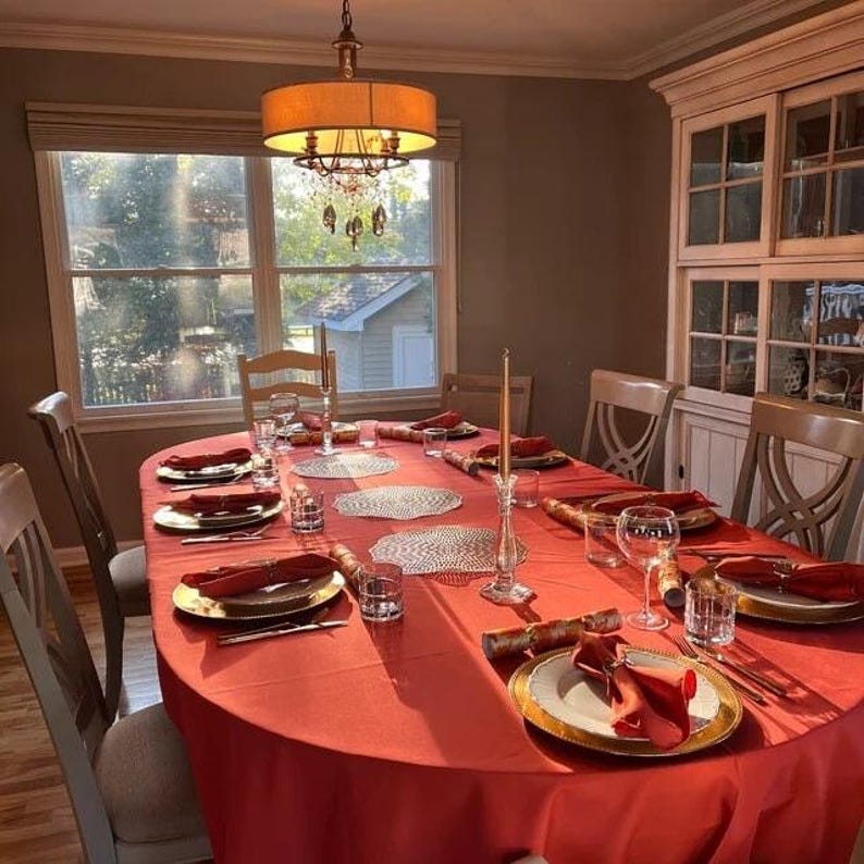 Fall tablecloth and orange napkins on a large custom size oval table.