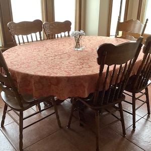 Damask tablecloth on oval table with white tulip vase