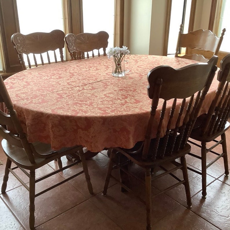 Damask tablecloth on oval table with white tulip vase