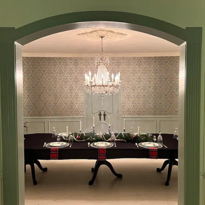 Black tablecloth and dinner napkins on a very large oblong table in a dining room with a beautiful chandelier.
