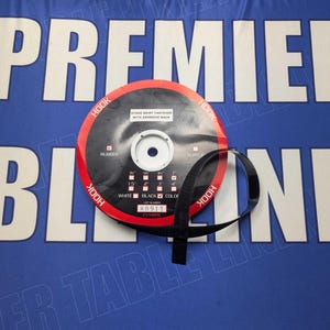 May include: A black and red hook and loop tape roll with the text "STITCH RESIST FASTENER WITH ADHESIVE BACK" and "HOOK" printed on the roll. The roll is labeled with "WHITE" and "BLACK" color options and has a measurement scale in inches.
