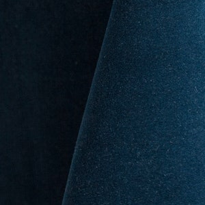 Close-up of a marine blue velvet upholstery fabric with a soft, textured surface.
It is 105,000 rub tested which is excellent durable quality manufactured by Premier Table Linens.