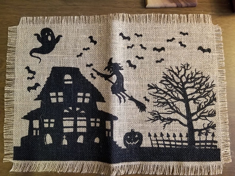 Halloween placemat with haunted house, witch and ghost.