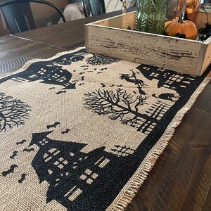 Halloween table runner with haunted house, witch and ghost.