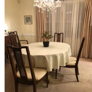 An ivory tablecloth on a custom oval table in the dining room of a home.