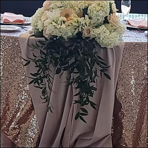 Blush velvet table runner over a sequin tablecloth. Beautiful white flowers on top of the table runner.