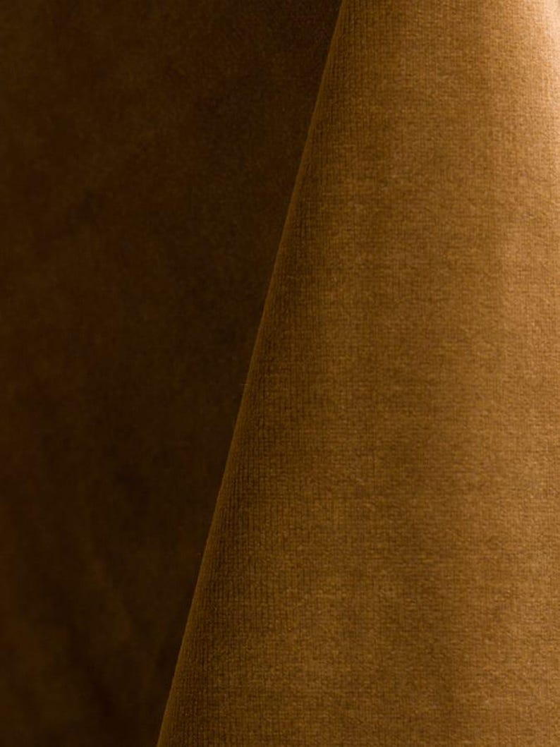 Close-up of a gold velvet upholstery fabric with a soft, textured surface.
It is 105,000 rub tested which is excellent durable quality manufactured by Premier Table Linens.