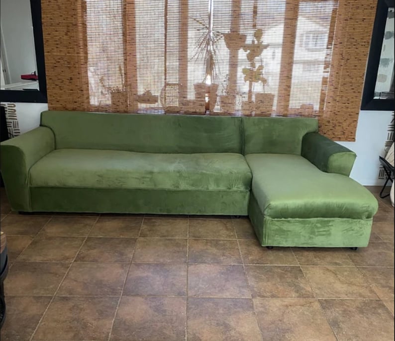 Puede incluir: Un sof&aacute; seccional grande de color verde oliva con una chaise longue en el lado derecho. El sof&aacute; cuenta con una tapicer&iacute;a de tela suave similar al terciopelo, un respaldo largo y apoyabrazos anchos en ambos extremos.