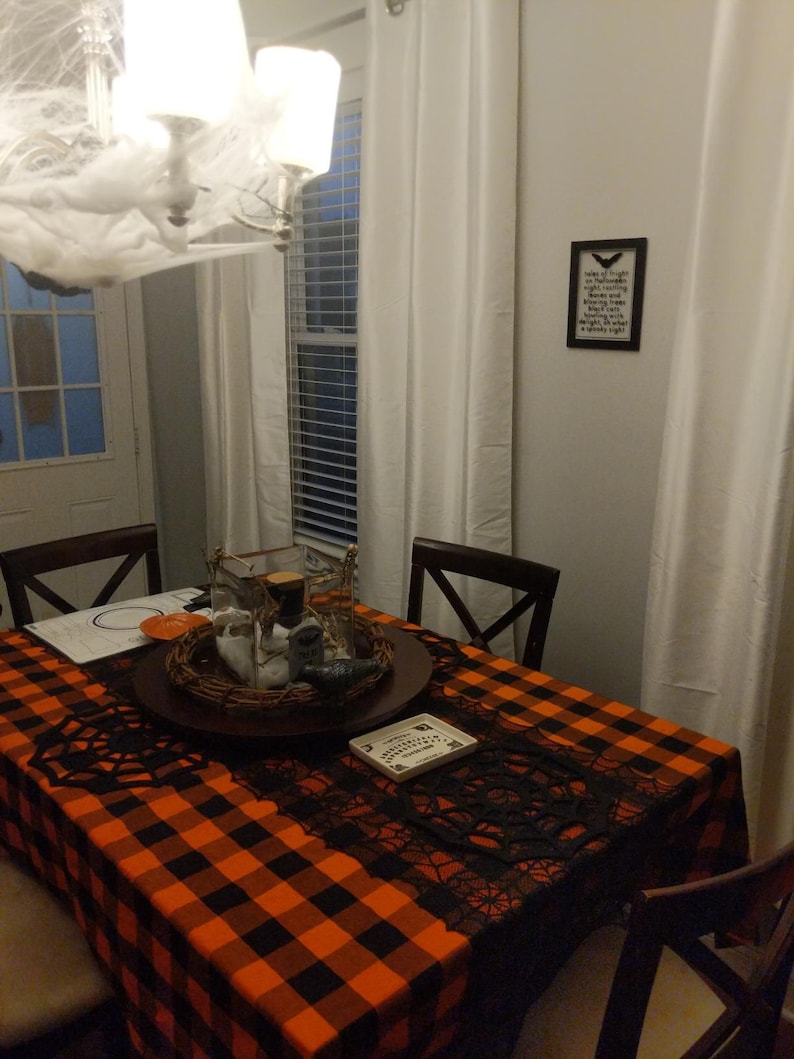 A black and orange checkered tablecloth. This fabric is also called Buffalo plaid tablecloth and is manufactured by Premier Table Linens.