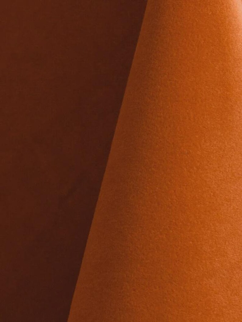 Burnt orange upholstery velvet manufactured by Premier Table Linens. They sell the upholstery velvet by the yard.