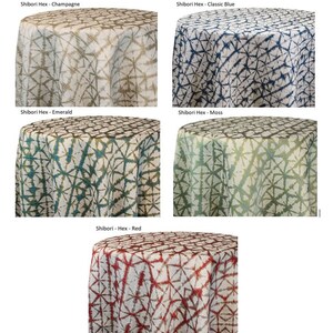 Five round Shibori tablecloths with a Shibori Hex pattern in various colors: champagne, classic blue, emerald, moss, and red. Each tablecloth is draped over a round table, showcasing the fabric's design.