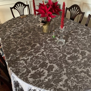 Chocolate oval tablecloth with red candle and red flowers