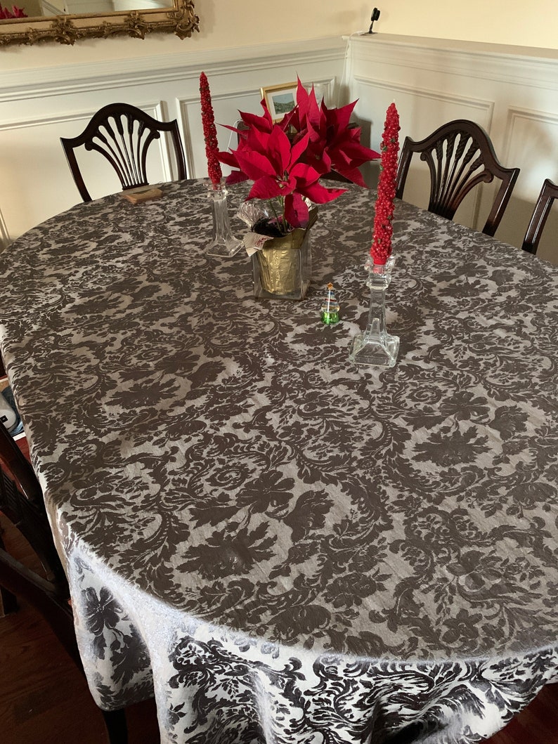 Chocolate oval tablecloth with red candle and red flowers