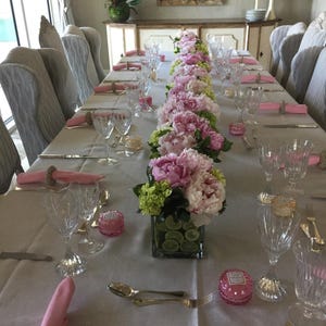 Linen tablecloth and twill cotton napkins on a long rectangular table set for a formal meal.