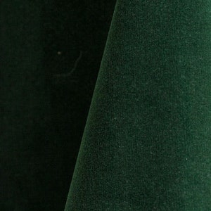 Close-up of the hunter green velvet upholstery fabric with a soft, textured surface.
It is 105,000 rub tested which is excellent durable quality manufactured by Premier Table Linens.