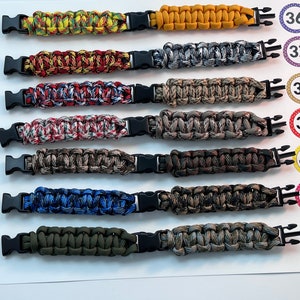 Puede incluir: Un conjunto de diez pulseras de paracord en varios colores y patrones, incluyendo camuflaje, rojo, amarillo y azul. Cada pulsera tiene una hebilla de pl&aacute;stico negro y est&aacute; numerada del 29 al 42.