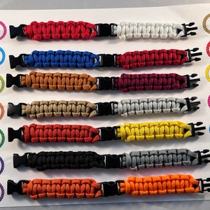 Puede incluir: Una muestra de 8 pulseras de paracord de diferentes colores con cierres negros. Las pulseras est&aacute;n numeradas del 1 al 8.
