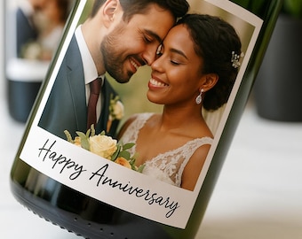 May include: Green champagne bottle with a custom label featuring a smiling couple. The label reads "Happy Anniversary" in elegant script. The bottle is partially visible, suggesting a celebratory theme.