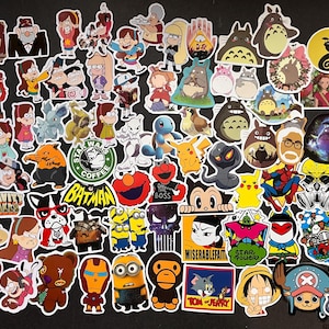 Puede incluir: Una colección de pegatinas coloridas con personajes de dibujos animados de Gravity Falls, Pokémon, Totoro, Batman y más. Las pegatinas varían en tamaño y forma, sobre un fondo negro.