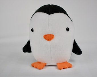 May include: A white and black plush penguin toy with orange feet and a black beak. The penguin has black eyes and a white belly.