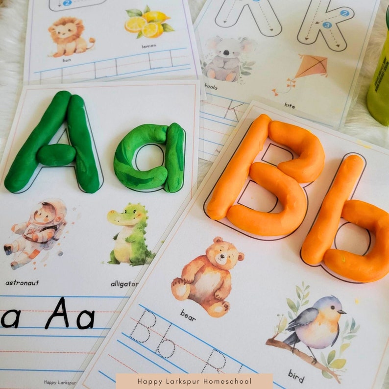 May include: A set of printable alphabet worksheets for kids featuring colorful playdough letters, illustrations of animals, and lines for tracing the letters. The text "Happy Larkspur Homeschool" is at the bottom of the page.