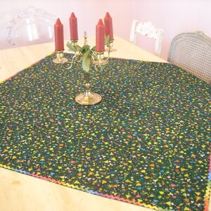 Sparkling Christmas cloth that can be used well into winter. Dark green with gold, pink, blue, white, and orange with holiday iconography.