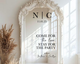 May include: A tall, ornate white floor mirror featuring intricate carved detailing along the frame. The glass surface displays black text reading N | C, 11.01.25, COME FOR the love. STAY FOR THE PARTY, xoxo. Nathan + Caitlyn in various fonts.
