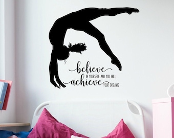May include: A black wall decal featuring the silhouette of a gymnast performing a backbend. Below the figure, the text reads: believe IN YOURSELF AND YOU WILL achieve YOUR DREAMS in a combination of script and sans-serif fonts.