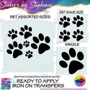 May include: A set of black paw print iron-on transfers featuring assorted sizes, a set of same size prints, and a single large print. The text reads Stickers by Stephanie, SET ASSORTED SIZES, SET SAME SIZE, SINGLE, and READY TO APPLY IRON ON TRANSFERS.