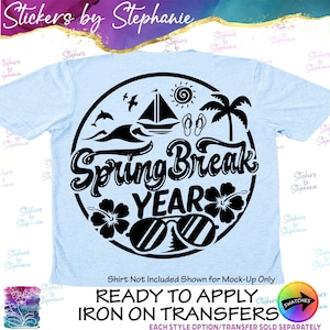 May include: A light blue t-shirt featuring a black circular graphic with the text Spring Break YEAR. The design includes a sailboat, sun, palm tree, hibiscus flowers, flip-flops, a dolphin, and sunglasses. The text below reads READY TO APPLY IRON ON TRANSFERS.