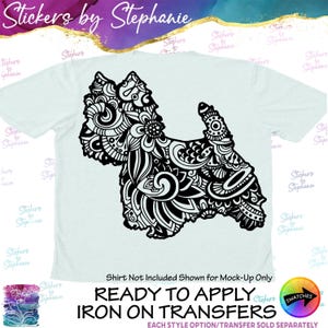 May include: A light blue t-shirt featuring a large black graphic of a dog silhouette filled with intricate floral and swirl patterns. The text "Stickers by Stephanie" appears at the top, with "READY TO APPLY IRON ON TRANSFERS" at the bottom.