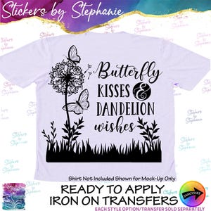 May include: A light purple t-shirt featuring a black graphic design of a dandelion, two butterflies, and grass. The text reads Butterfly KISSES & DANDELION wishes. The design is a ready to apply iron on transfer for fabric application.
