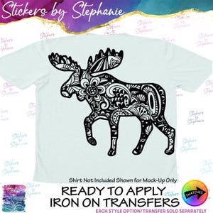 May include: A light blue t-shirt featuring a large black graphic of a moose filled with intricate floral and paisley patterns. The text "Stickers by Stephanie" appears at the top, and "Shirt Not Included Shown for Mock-Up Only" is at the bottom.