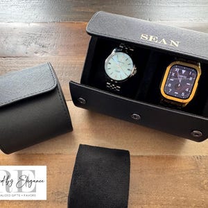 May include: Black leather watch roll with two watch slots. The roll is personalized with the name "SEAN".