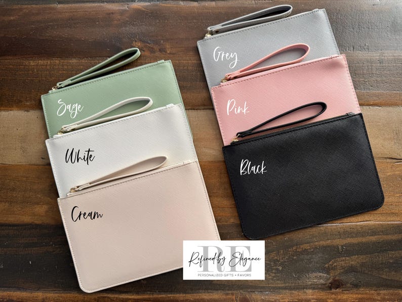 May include: A collection of six rectangular clutch bags in various colors: sage, white, cream, grey, pink, and black. Each bag has a matching wrist strap and a zipper closure. The names of the colors are written on each bag.