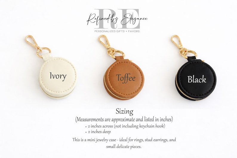 May include: Three small, round jewelry cases in ivory, toffee, and black, each with a gold-colored keychain clasp. The ivory case is labeled "Ivory", the toffee case is labeled "Toffee", and the black case is labeled "Black". Each case is approximately 2 inches across and 2 inches deep.