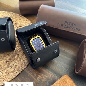 May include: Four different watch cases, two brown and two black. The black cases have a watch inside. The brown cases have the text "T.H." and "PAPA'S COLLECTION" embossed on them.