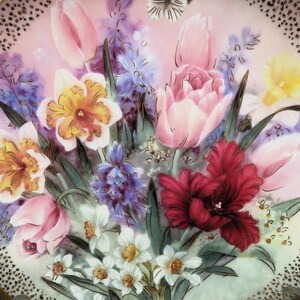 K&ouml;nnte beinhalten: Ein antiker Porzellan Teller mit einem Blumendesign mit rosa, gelben und roten Blumen. Die Blumen sind in einem realistischen Stil gemalt und von gr&uuml;nen Bl&auml;ttern umgeben. Der Teller hat einen goldenen Rand und einen wei&szlig;en Hintergrund.