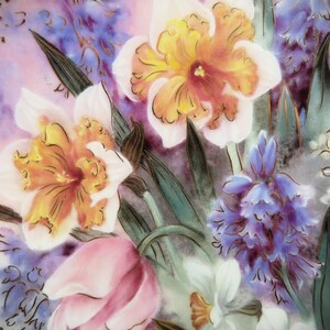 K&ouml;nnte beinhalten: Ein antiker Keramikteller mit einem Blumendesign mit rosa, gelben und blauen Blumen. Die Blumen sind realistisch gemalt und haben komplizierte Details. Der Teller hat einen wei&szlig;en Hintergrund mit einem dezenten Rosaton.