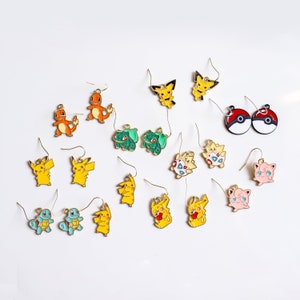 Puede incluir: Un conjunto de 16 pendientes coloridos con personajes de Pokemon. Los pendientes están hechos de metal y presentan una variedad de personajes de Pokemon, incluyendo Pikachu, Bulbasaur, Charmander, Squirtle y Jigglypuff.