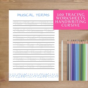May include: A white paper worksheet titled MUSICAL TERMS with light grey cursive text for tracing on black horizontal lines. A bright pink box displays 100 TRACING WORKSHEETS HANDWRITING CURSIVE. A white pencil and a row of coloured pencils are included.