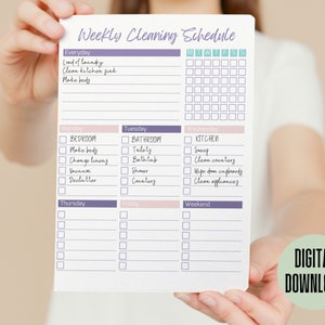 May include: A printable weekly cleaning schedule checklist with a purple and pink color scheme. The checklist includes daily, weekly, and specific room cleaning tasks. The text on the checklist includes "Weekly Cleaning Schedule", "Everyday", "Monday", "Tuesday", "Wednesday", "Thursday", "Friday", "Weekend", "Bedroom", "Bathroom", "Kitchen", "Load of Laundry", "Clean Kitchen Sink", "Make Beds", "Tidy", "Bathtub", "Shower", "Counters", "Sweep", "Clean Counters", "Wipe Down Cupboards", "Clean Appliances", "Change Linens", "Vacuum", "Declutter".