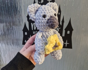 Blue and grey glittery yarn sitting koala made with chenille super soft yarn and safety eyes holding a sunflower