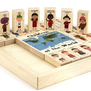 May include: Wooden blocks featuring children from different countries around the world. Each block has a child wearing traditional clothing, a greeting in the child's native language, and the country's name. The blocks are arranged in a circle around a world map, with the words "Children of the World" printed on the map.