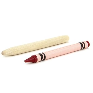 May include: A red crayon with black stripes and a wooden stick.