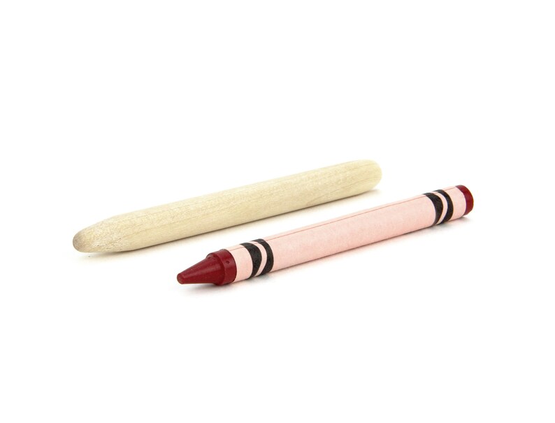 May include: A red crayon with black stripes and a wooden stick.